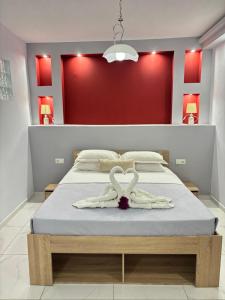 a bedroom with a bed with a heart towel on it at Panorama Apartments in Prinos
