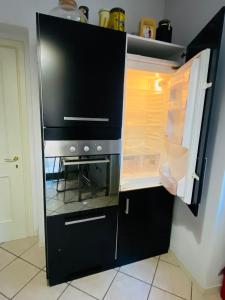 an empty refrigerator with its door open in a kitchen at La Casa di Amici Miei in Cremona