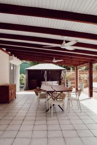 a patio with a table and chairs and an umbrella at Villa Massy in Rivière-Salée