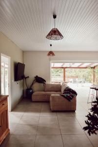 a living room with a couch and a tv at Villa Massy in Rivière-Salée