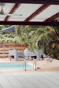 a patio with a table and chairs next to a pool at Villa Massy in Rivière-Salée