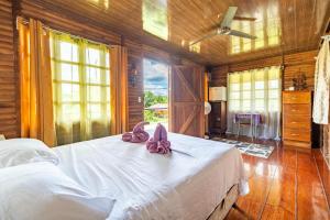 een slaapkamer met een bed met roze slippers erop bij Cabañas Retiro Del Rio in Guayabal