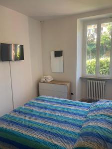 een slaapkamer met een bed en een raam bij VILLA AIDA LAKE VIEW in Lavena Ponte Tresa