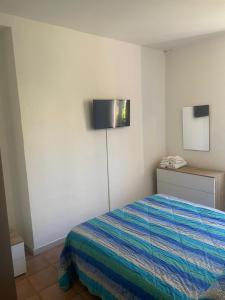een slaapkamer met een bed en een televisie aan de muur bij VILLA AIDA LAKE VIEW in Lavena Ponte Tresa