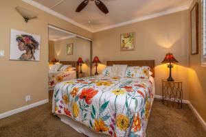 a bedroom with a bed and two lamps and a mirror at Maalaea Kai Resort 213 in Wailuku +40 photos