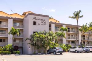 a building with cars parked in a parking lot at Maalaea Kai Resort 213 in Wailuku