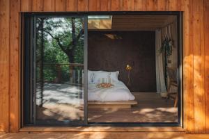 a bedroom with a bed through a sliding glass door at Idylle du Causse in Cénevières +33 photos