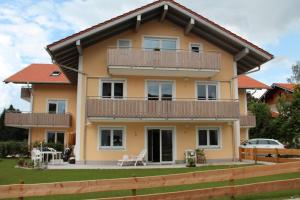 een huis met een balkon en een tuin bij Genusszeit am Chiemsee in Übersee