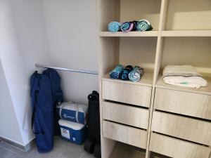 een kast met houten planken waarop schoenen en een rugzak staan bij Samaia Loft in Santa Marta