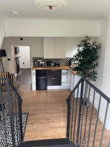 una cucina con scala che conduce a un soggiorno di Birdellas the eleganant one a Castle Donington