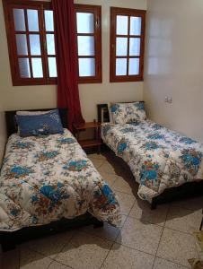 two beds sitting in a room with windows at Chez-soi in Meknès +40 photos
