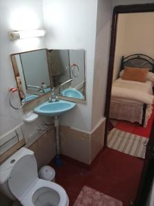un bagno con lavandino, WC e specchio di Palmas Magramane a Oulad el Guern