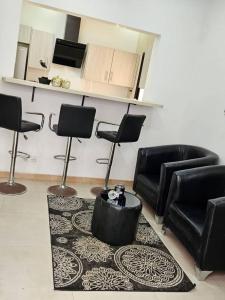 a living room with black chairs and a table at Sunset Senegal in Rufisque