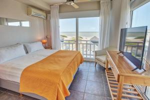 a bedroom with a bed and a desk with a television at Torrecillas Carilo in Carilo +116 photos