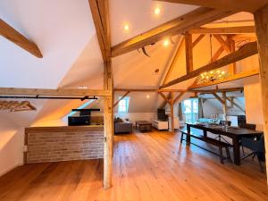 a dining room and living room with wooden beams at Loft am Wappach in Bayerisch Gmain +19 photos