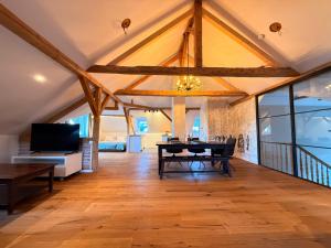 a dining room with a table and a tv at Loft am Wappach in Bayerisch Gmain