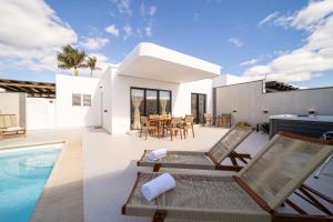 een villa met een zwembad en een huis bij Villa Moon in Tías