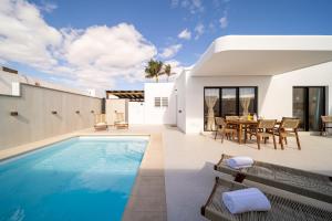 een villa met een zwembad en een patio bij Villa Moon in Tías