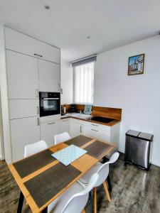 een keuken met een houten tafel en witte kasten bij escapade à Wimereux in Wimereux