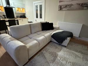 a white leather couch in a living room at The Nairn Neuk - Couples Cosy Getaway in Nairn