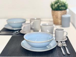 a table with blue bowls and cups on a table at BorgoLuce Spacious Apt - FREE Parking - Near Airport & Center in Bergamo