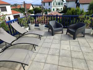 a patio with chairs and plants on a balcony at Appartement avec Terrasse à Beaurivage in Biarritz
