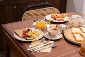 a table topped with plates of breakfast foods and orange juice at Joli Môme in Paris