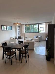 a large living room with a table and chairs at Depto centro in Villa Carlos Paz