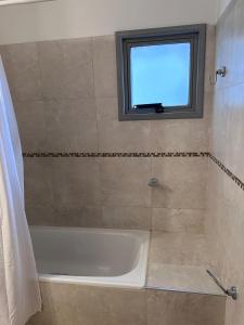 a bathroom with a bath tub and a window at Depto centro in Villa Carlos Paz