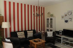 un soggiorno con parete a righe rosse e bianche di Haus Vis a Vis 1 a Stromberg