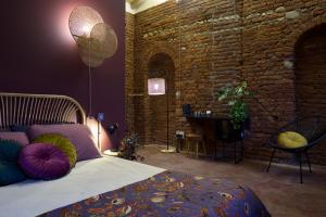 a bedroom with a bed and a brick wall at La SERAFINA in Vanzaghello