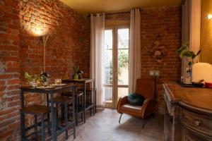 a room with a brick wall and a table and chairs at La SERAFINA in Vanzaghello