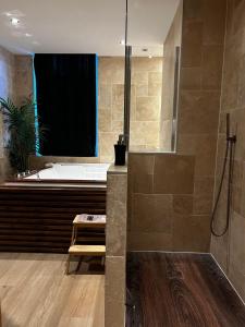 een badkamer met een ligbad en een wastafel bij Bella Notte Spa in Dijon