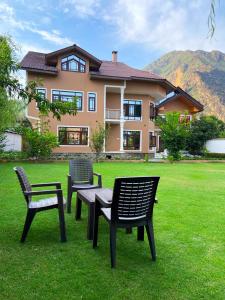 drie stoelen en een tafel voor een huis bij Haven Retreat in Srinagar
