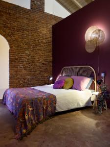 a bedroom with a bed and a brick wall at La SERAFINA in Vanzaghello