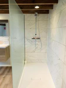 een badkamer met douche en witte marmeren muren bij vakantiewoning Het Boomkwekerijhuis in Zonnebeke +24 foto's