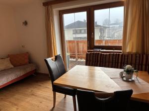a living room with a table and a large window at Ferienwohnung Mayrhofer in Leogang