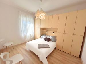 a bedroom with a large white bed and a chair at Duca - Gorizia City Apartment - 80 smq Central in Gorizia