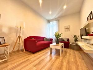 a living room with a red couch and a table at Duca - Gorizia City Apartment - 80 smq Central in Gorizia