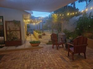 un patio con sedie e una scala con luci di Strandloper Room a Città del Capo