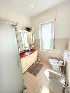 a bathroom with a sink and a toilet and a window at Duca - Gorizia City Apartment - 80 smq Central in Gorizia +12 photos