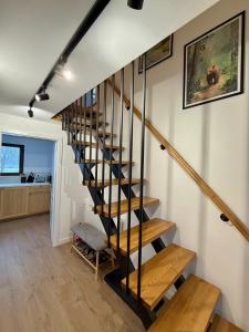 una scala a chiocciola in una casa con pavimenti in legno di Casuta Fulgu - Apartament 2 Dormitoare a Borşa Altre 10 foto