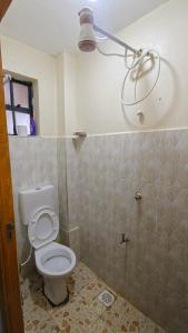 a bathroom with a toilet and a shower at Coral Homes in Juja
