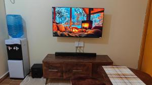 a room with a tv hanging on the wall at Coral Homes in Juja