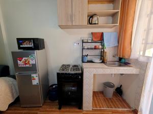 a small kitchen with a stove and a refrigerator at Coral Homes in Juja