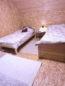 a bedroom with two beds and a table with a lamp at Alexandra Forest Lake House in Konsu