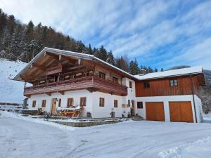een huis in de sneeuw voor bij Ferienwohnung Grabenhäusl inkl. Chiemgaukarte in Ruhpolding