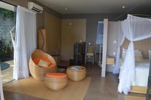 a bedroom with a bed and two chairs and a bed at Vila Pedra Mar in Praia Vermelha