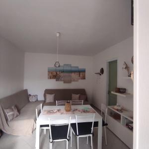 a living room with a table and a couch at casa MAREA in Lido Marini