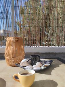 a table with a plate of eggs and a cup of coffee at casa MAREA in Lido Marini